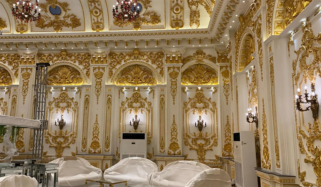 Hall with ornate gold mouldings, arches and painted ceiling