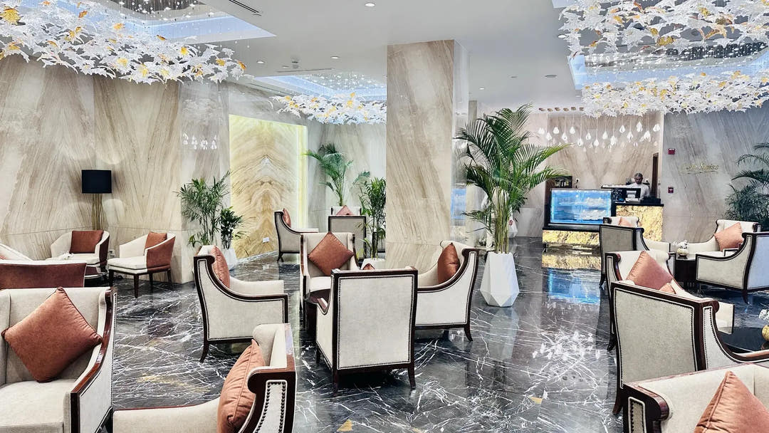 Hotel lobby styled with white geometric planters and artificial palms